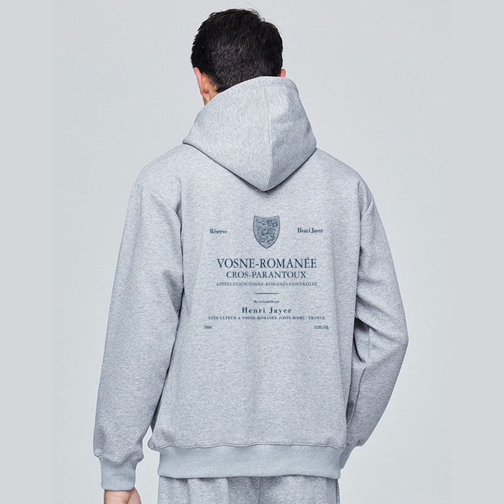 Person wearing a gray hoodie with branding on the back against a light gray background