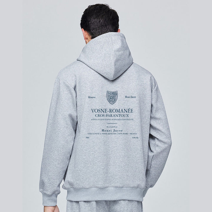 Person wearing a gray hoodie with branding on the back against a light gray background